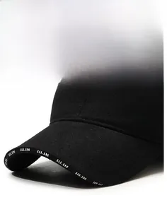 Detail view of winter baseball cap brim with 10.18 print and silver fashion metal plate