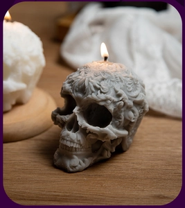 Detailed macro shot of a grey skull candle with intricate embossed floral carvings