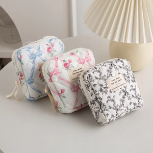 Quilted cotton cosmetic bags with floral and bow patterns in a lifestyle setting