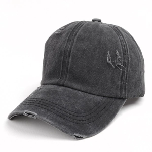 Close-up of distressed washed denim baseball cap featuring vintage ripped hole details