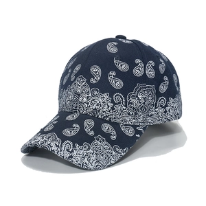 Detailed side view of navy blue baseball cap featuring white paisley print and curved brim