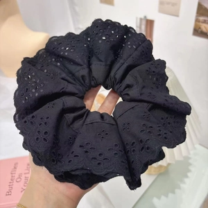 Detailed close-up of a black lace embroidery scrunchie with intricate floral patterns