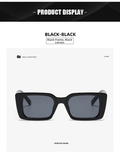 Front view of modern black rectangular sunglasses with dark lenses on white background