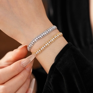 Close-up of double-row rhinestone chain bracelets in gold and silver finish on wrist