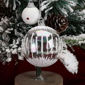 Close-up of iridescent Christmas ball with snowy texture hanging on a decorated tree