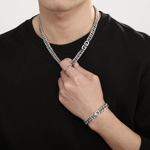 Polished stainless steel Cuban link necklace and bracelet set worn by a male model