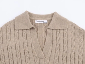Detail of cable knit polo neck sweater with V-opening and beige textured fabric