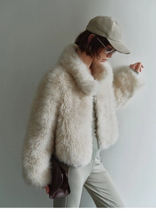 Detailed texture of cream faux fox fur vest with plush finish and minimalist stand collar