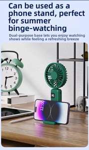 Detail of a dark green portable fan used as a desktop phone stand with LED digital display