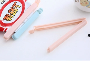 Detail of pink and light blue plastic sealing clips securing food snack bags tightly