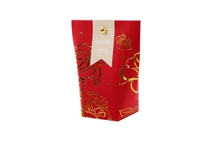 Detail of red wedding gift bag with gold foil flower pattern and Thank You tag