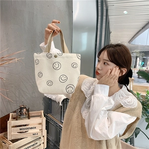 Close-up of white corduroy tote bag featuring black smiley prints for a vintage aesthetic