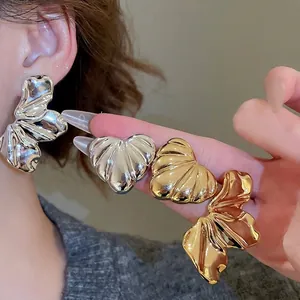 Textured metallic heart earrings in silver and gold finishes with pleated shell patterns