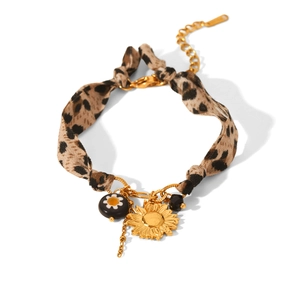 Detail of leopard print ribbon bracelet with golden sunflower pendant and black beads