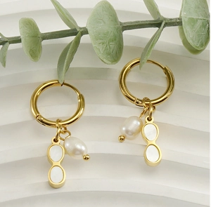Detail of 18K gold earrings with white shell number eight and natural freshwater pearls
