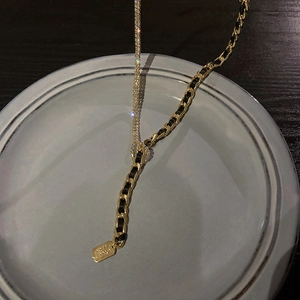 Vue macro du pendentif Good Luck avec chaîne cubaine dorée et strass brillants