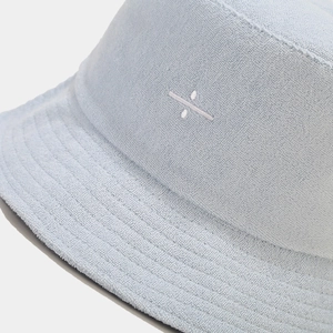 Detailed close-up of light blue terry cloth bucket hat featuring embroidered logo