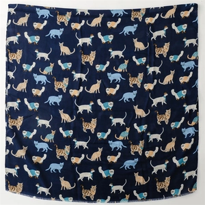 Detail of navy cotton-linen scarf featuring repeated cartoon cat patterns with raw edges