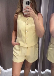 Close-up of yellow sleeveless V-neck vest and matching loose shorts with side pockets
