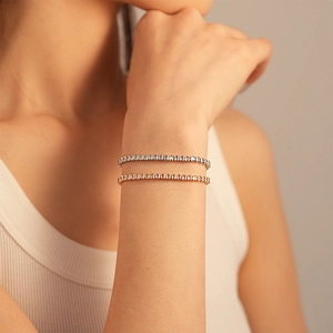 Détail de bracelets tennis superposés en argent et or rose avec oxydes de zirconium
