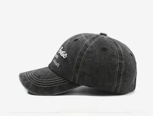Detail of dark grey washed denim baseball cap with white embroidery and contrast stitching