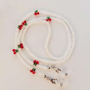 Detail of beaded glasses chain featuring red cherry accents and clear white beads