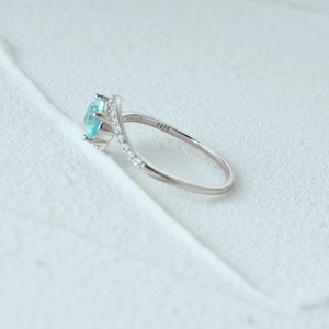 Macro view of S925 sterling silver ring with light blue center stone and small side diamonds