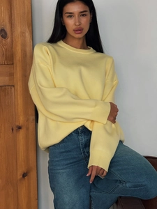 Women's casual light yellow crewneck knit sweater paired with blue straight jeans