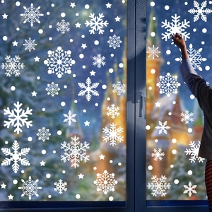 White snowflake window stickers in various sizes on glass with festive winter background