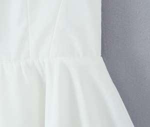 Close-up of white princess dress fabric showing fine texture and sewing details
