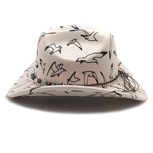 Close-up of western cowboy hat featuring seagull print and beaded band with silver coin