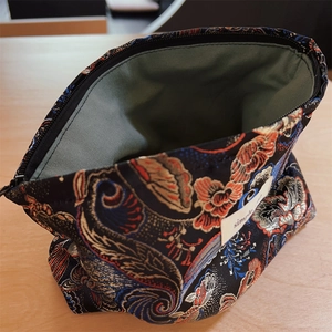 Close-up of brocade makeup bag with ethnic floral patterns and green fabric lining