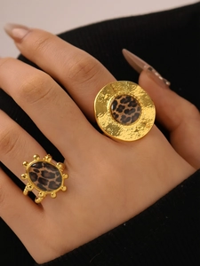 Detail of 18K gold stainless steel rings with leopard print inlay on textured metal