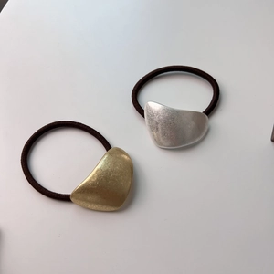 Close-up of minimalist gold and silver matte metal hair ties with elastic cords