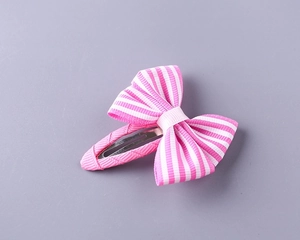 Close-up of pink and white striped ribbon bow hair clip with fabric-wrapped metal base