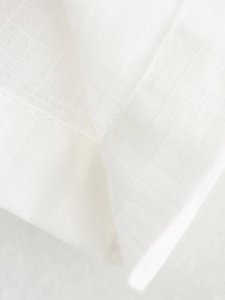 Close-up detail of white cotton linen fabric texture and fine stitching craftsmanship