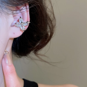 Detailed view of a silver star-shaped ear cuff with sparkling zircon on the model ear