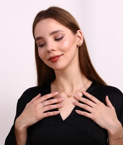 Model wearing a gold bow jewelry set with matching earrings, necklace and diamond ring