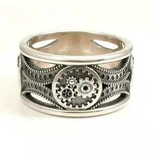 Macro detail of steampunk gear reliefs and industrial mechanical textures on a silver ring