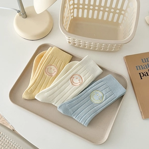 Three pairs of pastel cotton crew socks with embroidered smiley face in cream tray