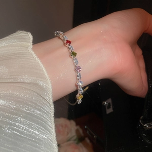 Close-up of a silver bracelet with colorful cubic zirconia stones on a model's wrist