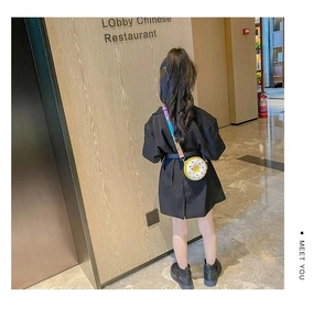 Rear view of a child wearing a donut-shaped silicone crossbody bag with colorful strap