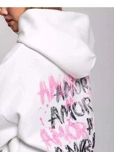 Detail of white hoodie featuring pink and black AMOR graffiti print on the back fabric