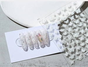 Gros plan de stickers à ongles 3D avec motifs papillons en relief et détails floraux