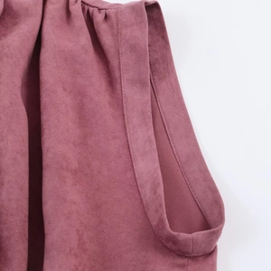 Détail du tissu en suédine rose poudré avec coutures précises et texture douce