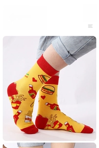 Detail of yellow mid-calf socks with burger fries patterns and red contrast accents