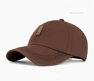 Close-up of coffee-colored washed cotton baseball cap with brown leather label and rivets