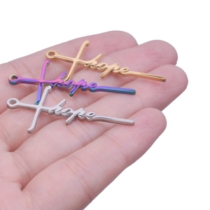 Three Hope word pendants in gold silver and rainbow finish shown on palm for size