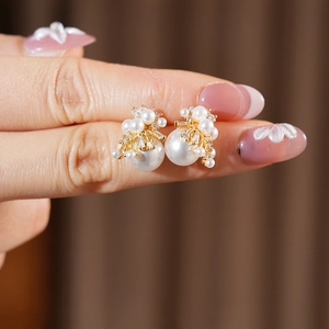 Nahaufnahme eleganter Perlenohrringe mit floralen Gold-Zirkonia-Details