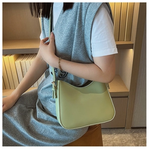 Détail du sac à bandoulière en cuir vert avocat avec bandoulière réglable sur modèle